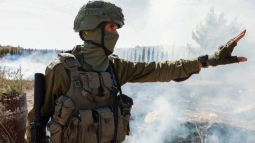An Israeli soldier gestures after pushing away Palestinian farmers and foreign activists, preventing ...