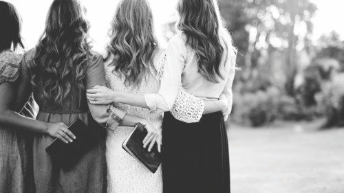 A beautiful shot from behind of females with their arms around each other while holding the bible in ... A beautiful shot from behind of females with their arms around each other while holding the bible in ...