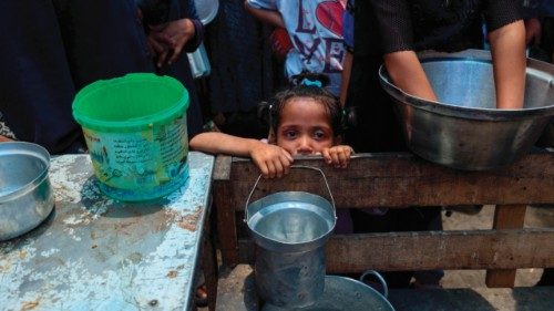 TOPSHOT - A girl waits with others to receive food at a distribution point in Nuseirat, central Gaza ...