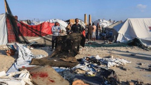 Palestinians inspect the damage at the site of an Israeli airstrike on a tent sheltering displaced ... Palestinians inspect the damage at the site of an Israeli airstrike on a tent sheltering displaced ...