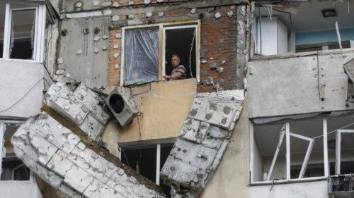 epaselect epa12159486 A local man looks out from a window of a high-rise residential building struck ... epaselect epa12159486 A local man looks out from a window of a high-rise residential building struck ...