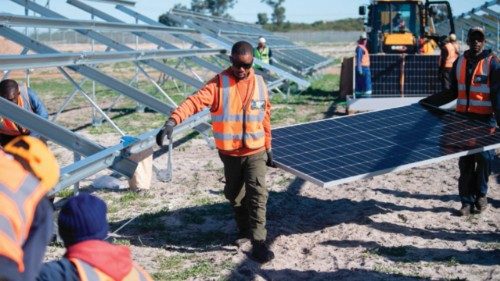 Workers carry solar panels to be fitted onto frames during construction at South Africa?s first ... Workers carry solar panels to be fitted onto frames during construction at South Africa?s first ...