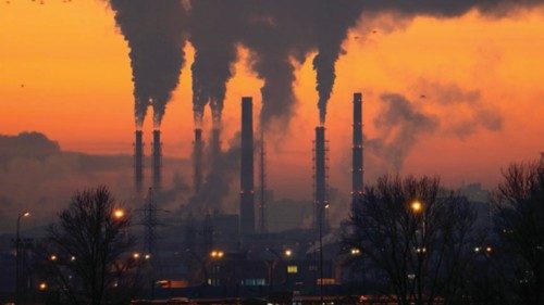 Smoke from heating station in big city during winter season at sunset. Smokestack pipes emitting co2 ...