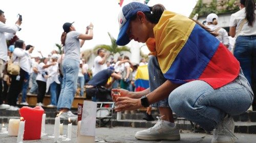 epa12164403 A woman lights a candle during a demonstration in Cali, Colombia, 08 June 2025. In ...