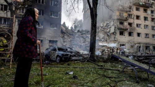 A woman looks at a partially collapsed apartment building after a Russian missile strike, amid ... A woman looks at a partially collapsed apartment building after a Russian missile strike, amid ...