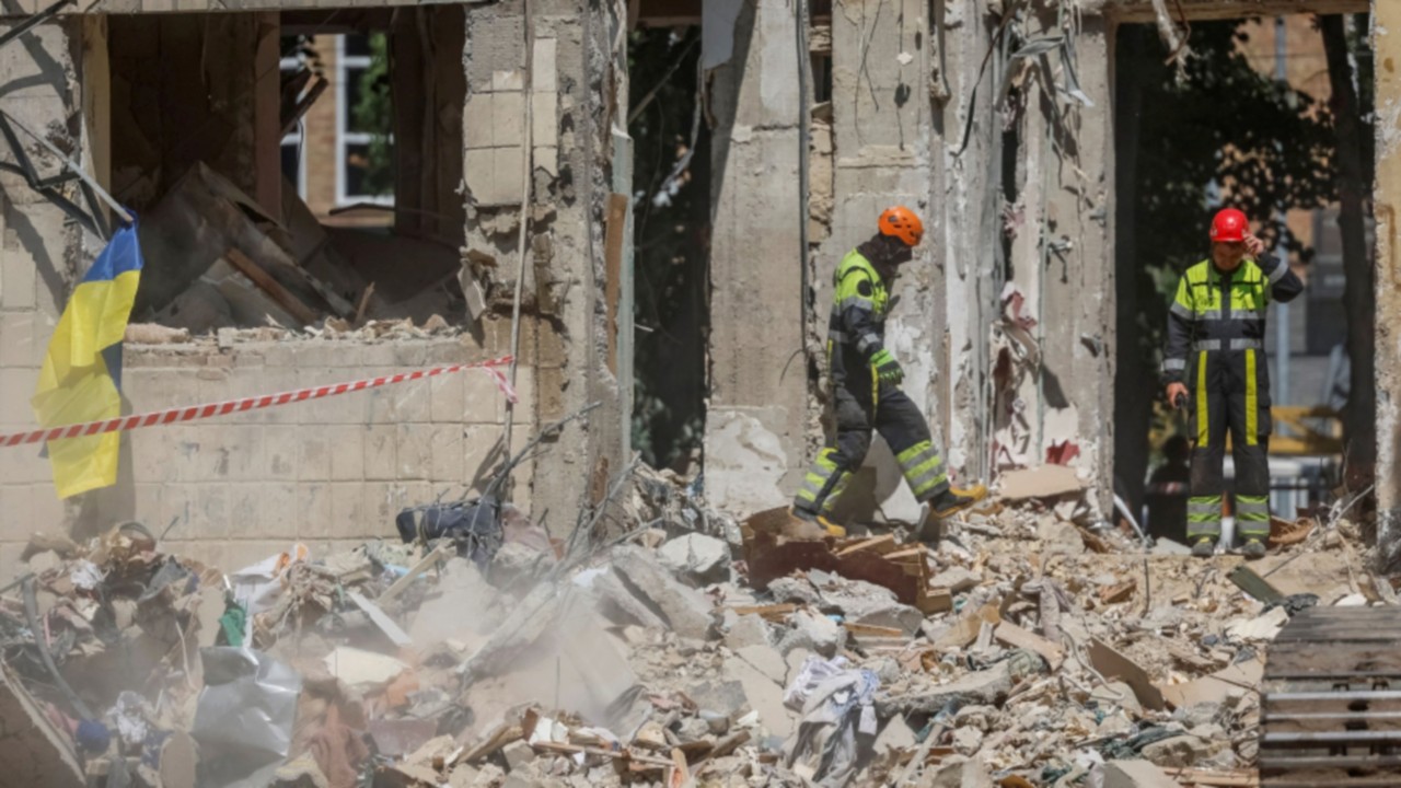 Rescuers search for the body of a person under debris of an apartment building hit by a Russian ...