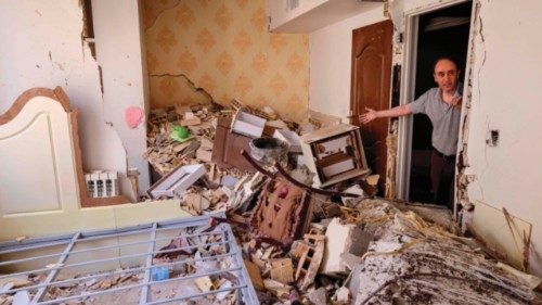 A resident gestures as he shows the destruction in his building after it was hit in an Israeli ...