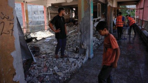Displaced Palestinians check the destruction in a classroom used as a temporary shelter, inside a ... Displaced Palestinians check the destruction in a classroom used as a temporary shelter, inside a ...