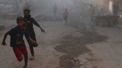 Palestinian children run near debris, amid dust, following an Israeli air strike on a house in Gaza ...