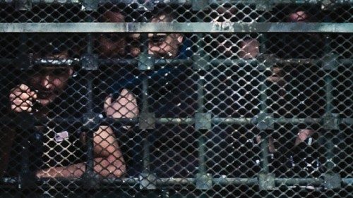 Inmates hang on to bars behind windows of a wing as they stage a protest at the San Vittore prison ...