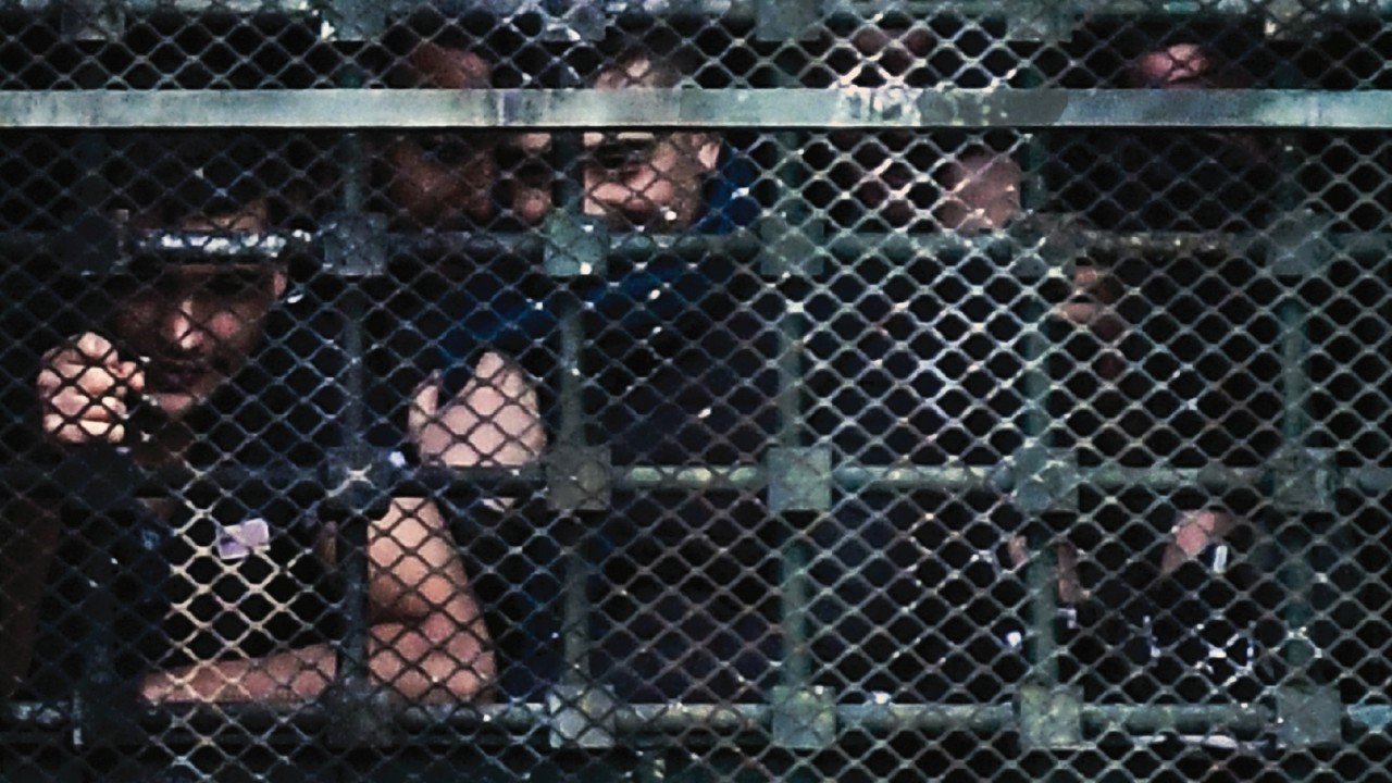 Inmates hang on to bars behind windows of a wing as they stage a protest at the San Vittore prison ...