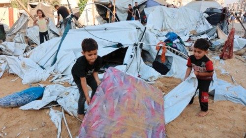 Palestinian little children lift a sand covered mattress after the Israeli army targeted the tents ... Palestinian little children lift a sand covered mattress after the Israeli army targeted the tents ...
