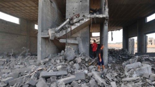 Palestinians walk amid the rubble of a building hit in an Israeli strike in the Bureij refugee camp ... Palestinians walk amid the rubble of a building hit in an Israeli strike in the Bureij refugee camp ...