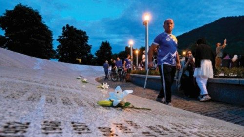 A visitor walks past the 'Memorial wall' at the memorial cemetery in village of Potocari, near the ... A visitor walks past the 'Memorial wall' at the memorial cemetery in village of Potocari, near the ...