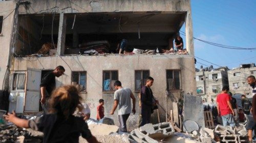 Palestinians inspect the damage at the site of an overnight Israeli strike on a school in Jabalia in ...