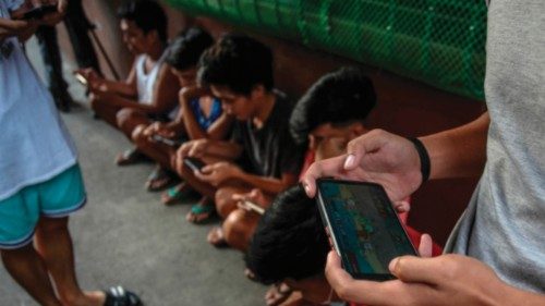 This photo taken on December 15, 2021 shows people using their mobile phones to play Axie Infinity, ... This photo taken on December 15, 2021 shows people using their mobile phones to play Axie Infinity, ...