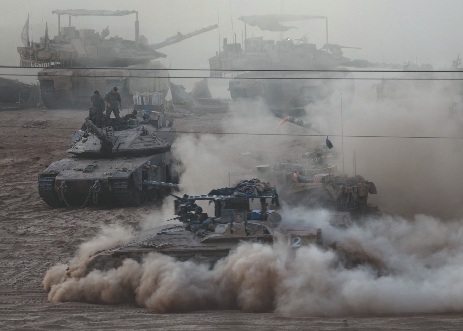 An Israeli APC manoeuvres next to other military vehicles on the Israeli side of the Israel-Gaza ...
