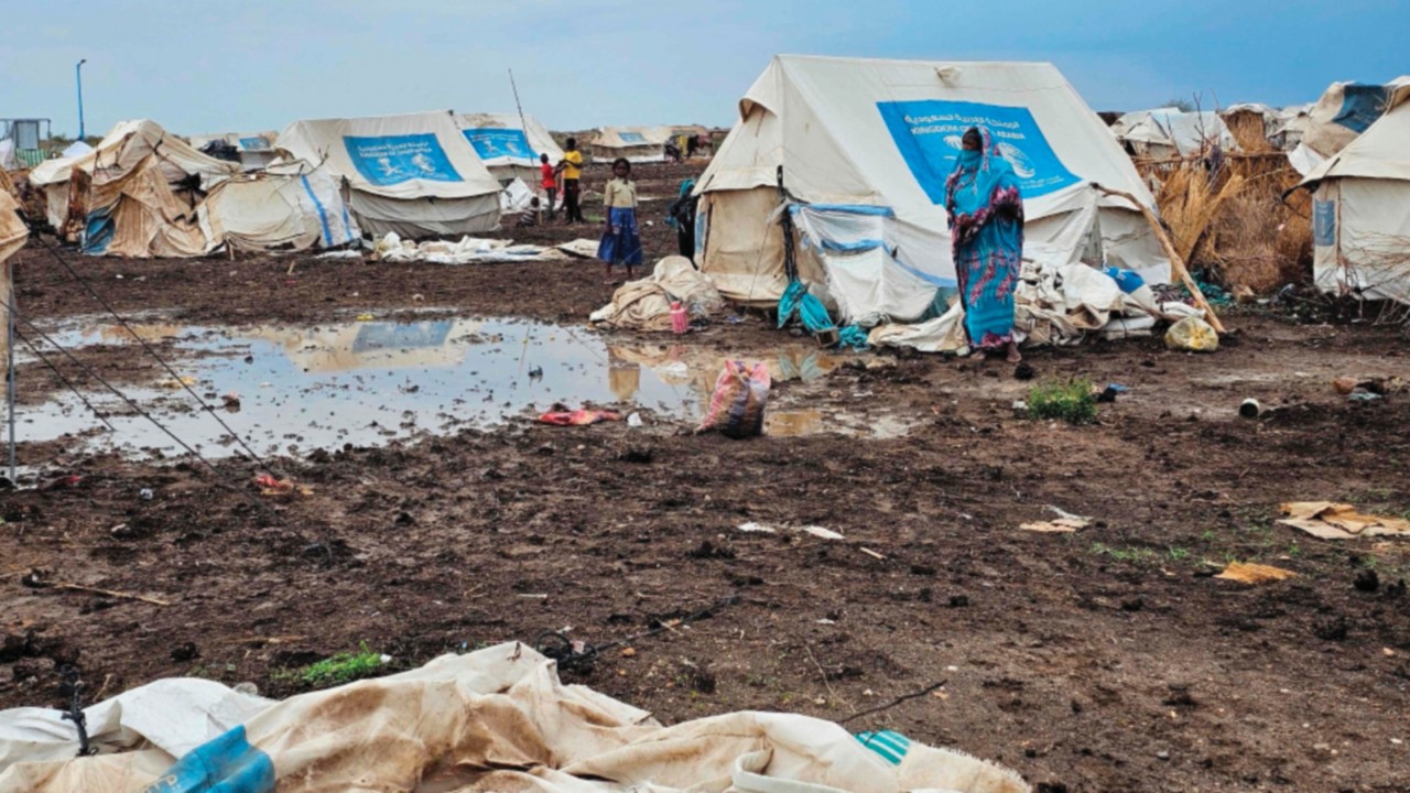 Mud covers the ground around tents at the Abu Al-Naja camp for displaced Sudanese in the eastern ...