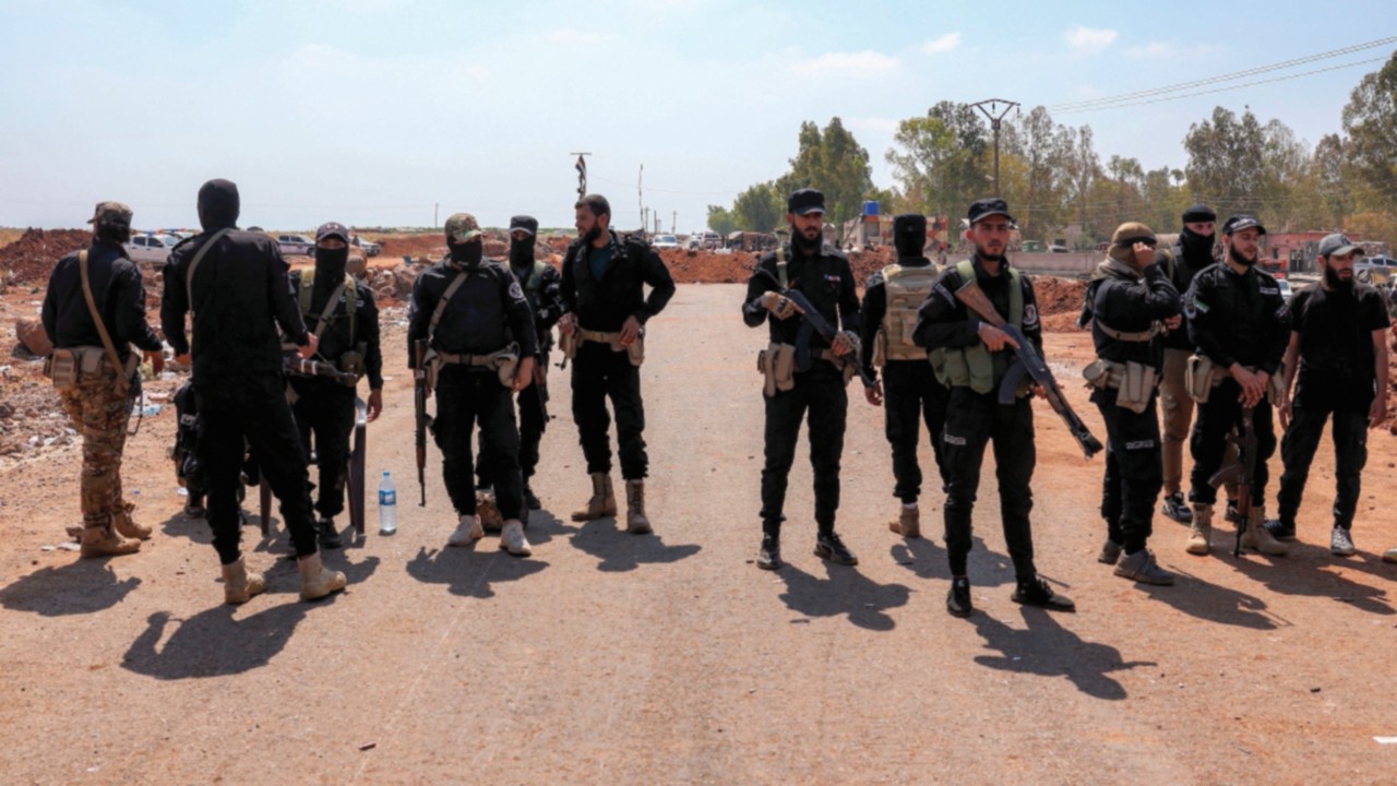 TOPSHOT - Syrian government security forces stand near an earth barrier that they created as a ...