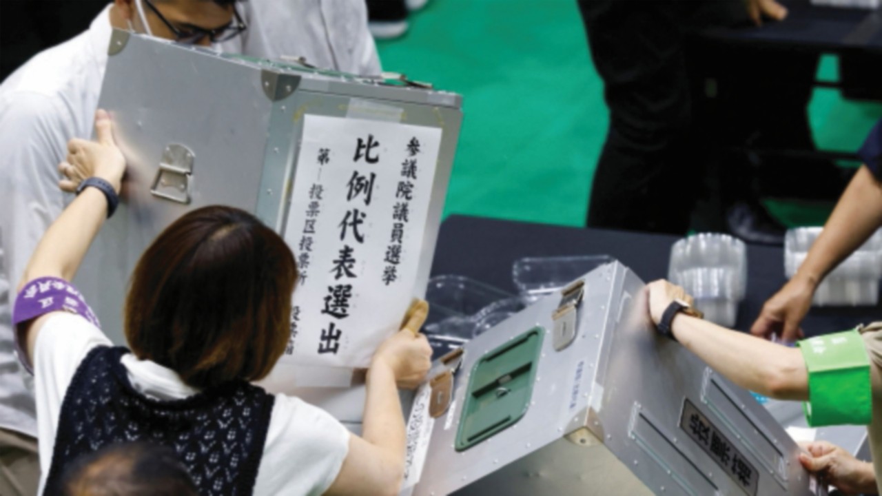 Election officials open ballot boxes during Japan's upper house election at a counting centre in ...