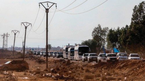 TOPSHOT - A United Nations convoy evacuating families from Sweida moves through the buffer zone in ...