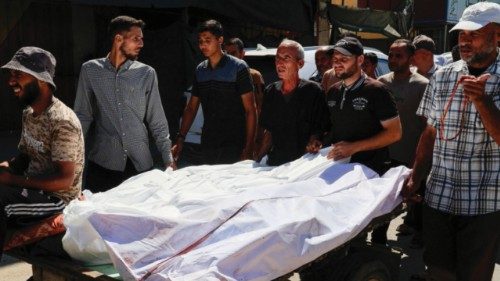Mourners stand next to the bodies of Palestinians killed in an early morning Israeli airstrike on a ... Mourners stand next to the bodies of Palestinians killed in an early morning Israeli airstrike on a ...
