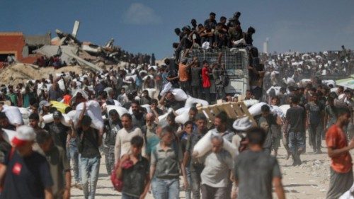 Palestinians carry aid supplies that entered Gaza through Israel, in Beit Lahia, northern Gaza ...