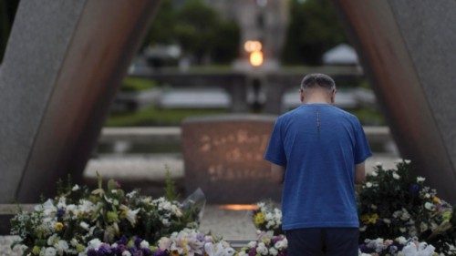 epa12283551 A man offers prayers before the Cenotaph for the Atomic Bomb victims at the Peace ...