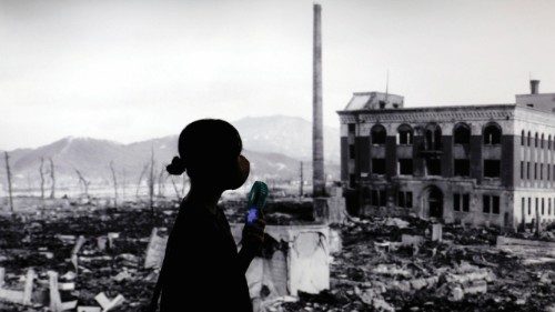 epa12283785 A visitor using a fan walks past a huge picture of Hiroshima devastated by the world's ...