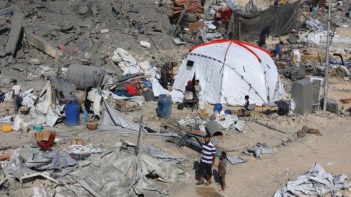 Palestinians inspect the site surrounding an evacuated UNRWA clinic where displaced people were ...