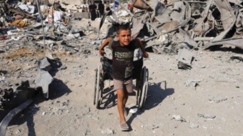 A Palestinian boy pulls a wheelchair at the site surrounding an evacuated UNRWA clinic where ... A Palestinian boy pulls a wheelchair at the site surrounding an evacuated UNRWA clinic where ...