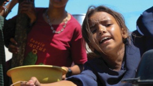 A Palestinian girl gestures as she waits to receive food from a charity kitchen, amid a hunger ... A Palestinian girl gestures as she waits to receive food from a charity kitchen, amid a hunger ...