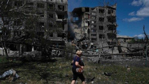 TOPSHOT - A woman walks past a heavily damaged residential building following a Russian strike in ... TOPSHOT - A woman walks past a heavily damaged residential building following a Russian strike in ...