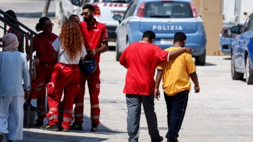 Members of the Italian Red Cross speak to each other outside the hotspot, a reception centre for ... Members of the Italian Red Cross speak to each other outside the hotspot, a reception centre for ...