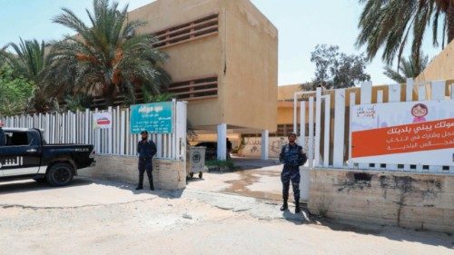 Libyan security officers stand guard outside a school used as a polling station as people vote in ... Libyan security officers stand guard outside a school used as a polling station as people vote in ...