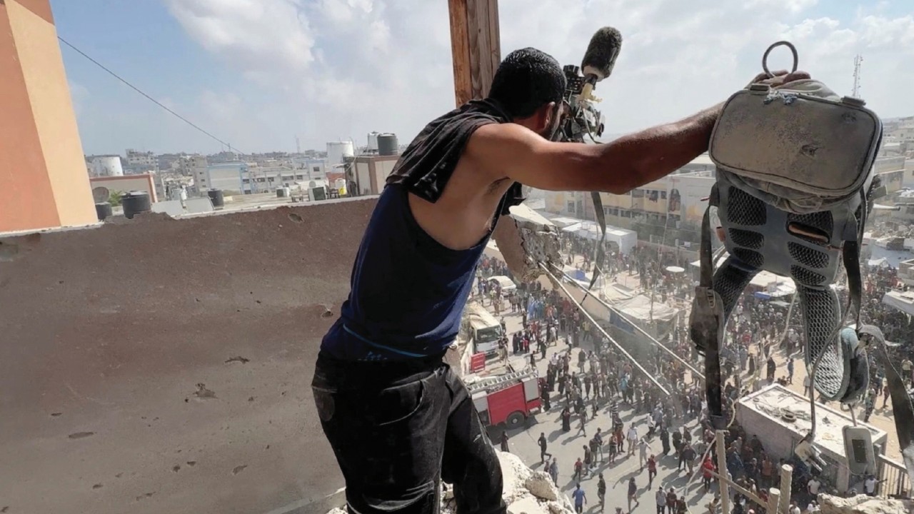 A man reacts as he holds the equipment used by Palestinian cameraman Hussam al-Masri, who was a ...