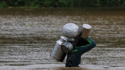 A resident carries milk buckets as he crosses a flooded road, due to the monsoon rains and rising ... A resident carries milk buckets as he crosses a flooded road, due to the monsoon rains and rising ...