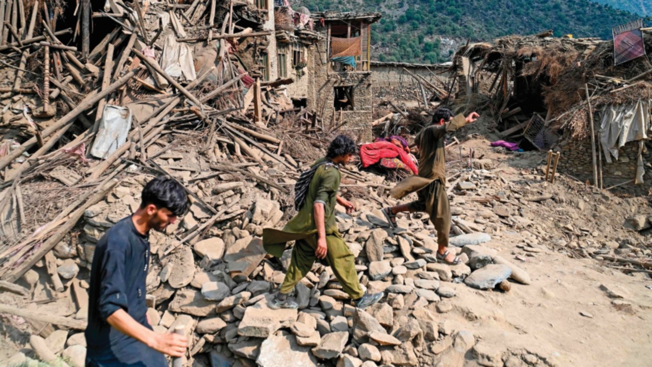 EDITORS NOTE: Graphic content / Afghans walk past damaged houses, after earthquakes at Mazar Dara ...