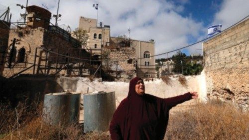 A Palestinian woman reacts near house at the entrance of the Palestinian market in the old city of ... A Palestinian woman reacts near house at the entrance of the Palestinian market in the old city of ...