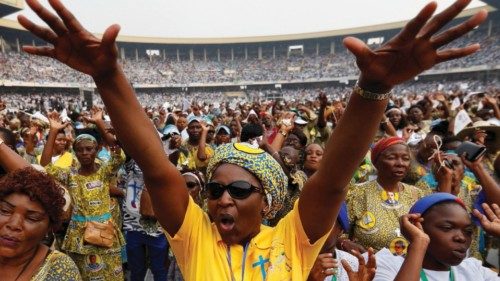 A woman gestures as people gather for Pope Francis' address at the Stade des Martyrs during his ...
