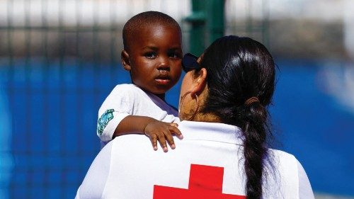 A Red Cross volunteer cares for a migrant baby after disembarking from a Spanish coast guard vessel, ...