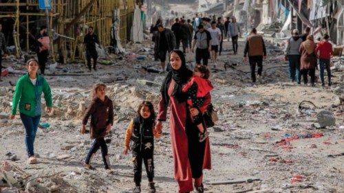 TOPSHOT - Palestinians walk amid the rubble of destroyed buildings in Gaza City on the northern Gaza ...