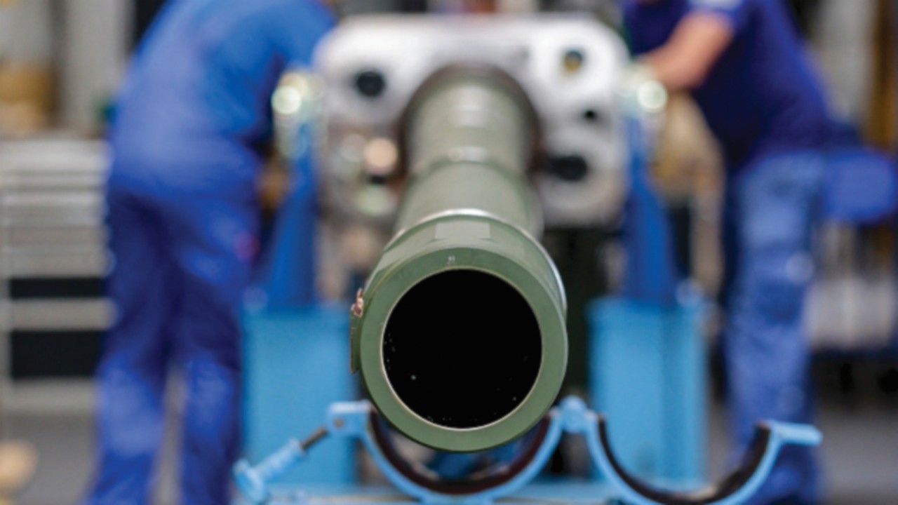 Technicians of German armaments company and automotive supplier Rheinmetall work on a 120mm cannon ...