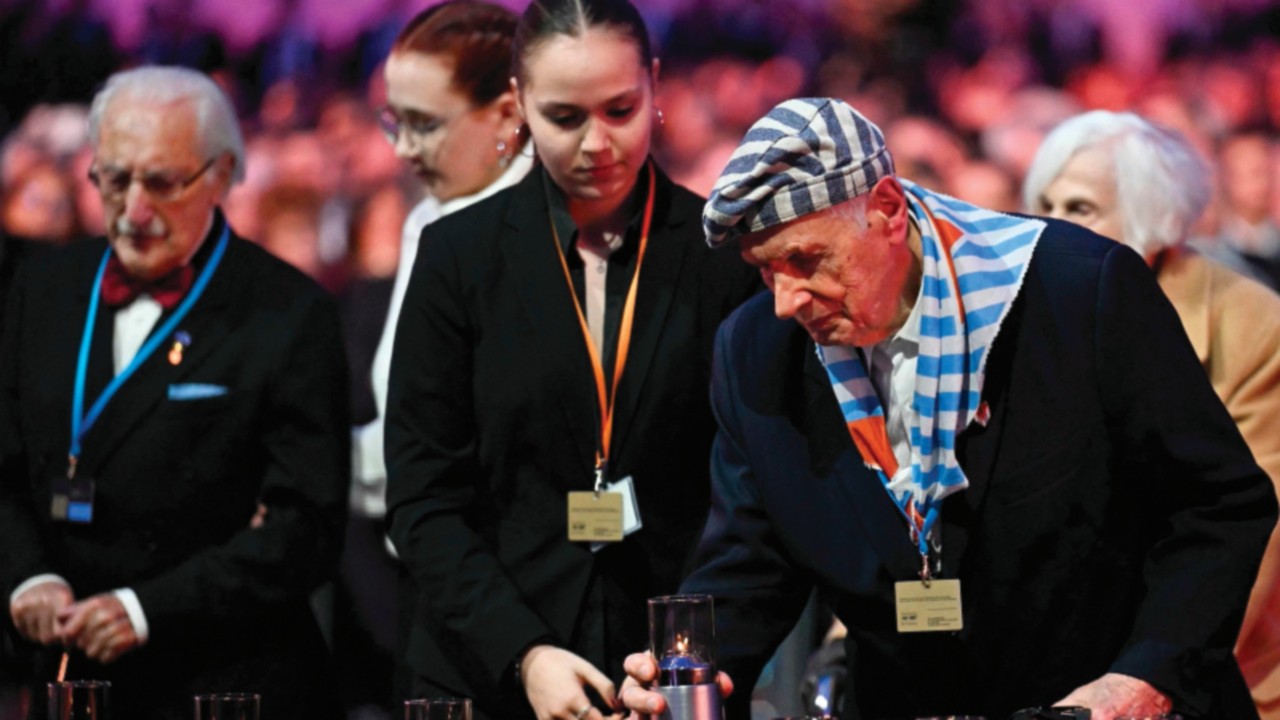 TOPSHOT - Survivors place votive candles in front of the train car, the symbol of the event, to pay ...