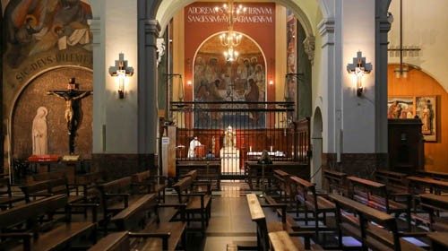 A priest serves a mass inside a chapel of an almost empty church in the Raval neighbourhood, as the ...
