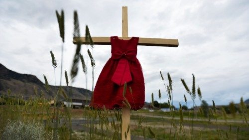 Vestido vermelho de criança pendurado numa cruz perto da antiga Escola Residencial Indígena em Kamloops, British Columbia, Canadá, depois de terem sido encontrados os restos mortais de 215 crianças, algumas com apenas três anos de idade (Jennifer Gauthier/Reuters)
