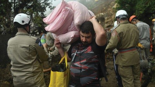 A man holds his belongings after leaving his house due to a giant landslide in Petropolis, Brazil, ...