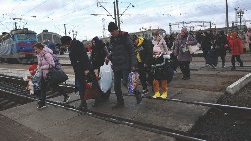 Refugees fleeing the ongoing Russian invasion of Ukraine cross the tracks after arriving on a train ...
