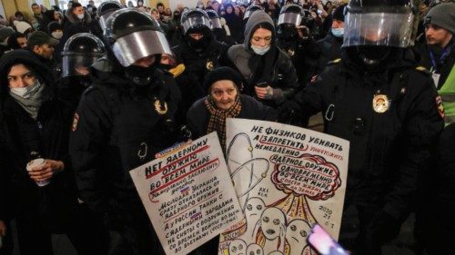 Law enforcement officers escort an elderly artist and activist, Yelena Osipova, during an anti-war ...