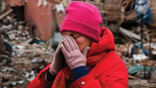 TOPSHOT - Irina Moprezova, 54, reacts in front of a house that was damaged in an aerial bombing in ...